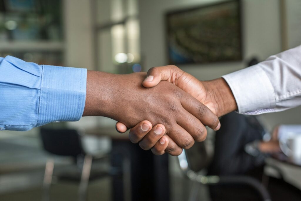 Two business partners shaking hands after agreeing a wholesale partnership