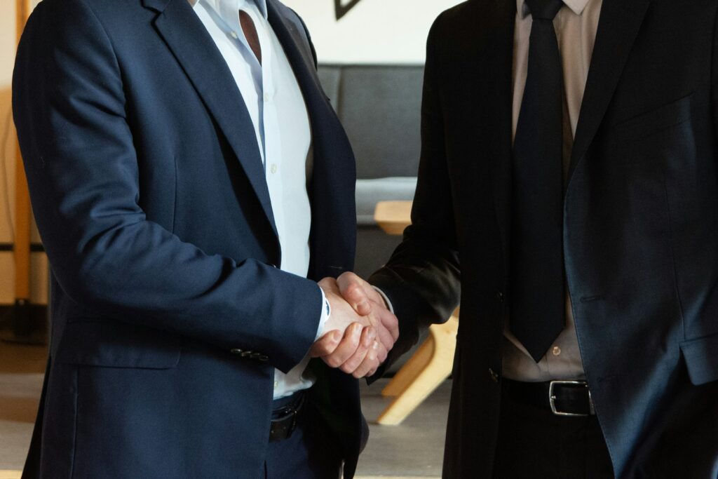 Brand owner and retail partner shaking hands as one of our brand partnerships begins