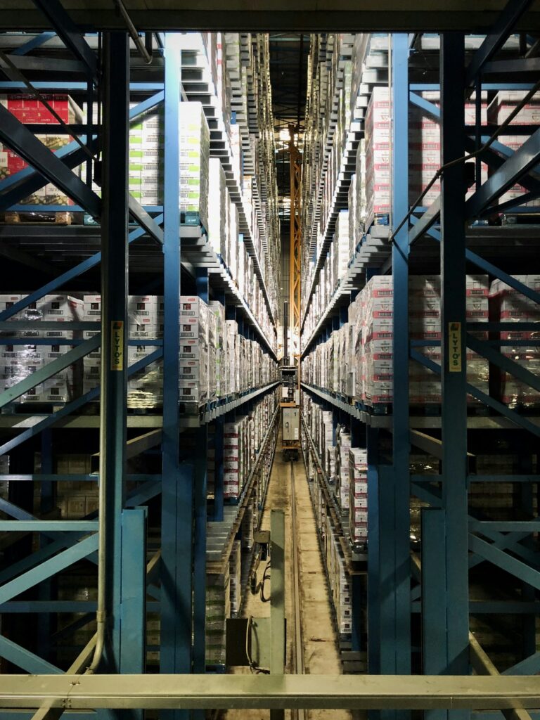 Warehouse aisle with tall shelving stocked with boxed inventory